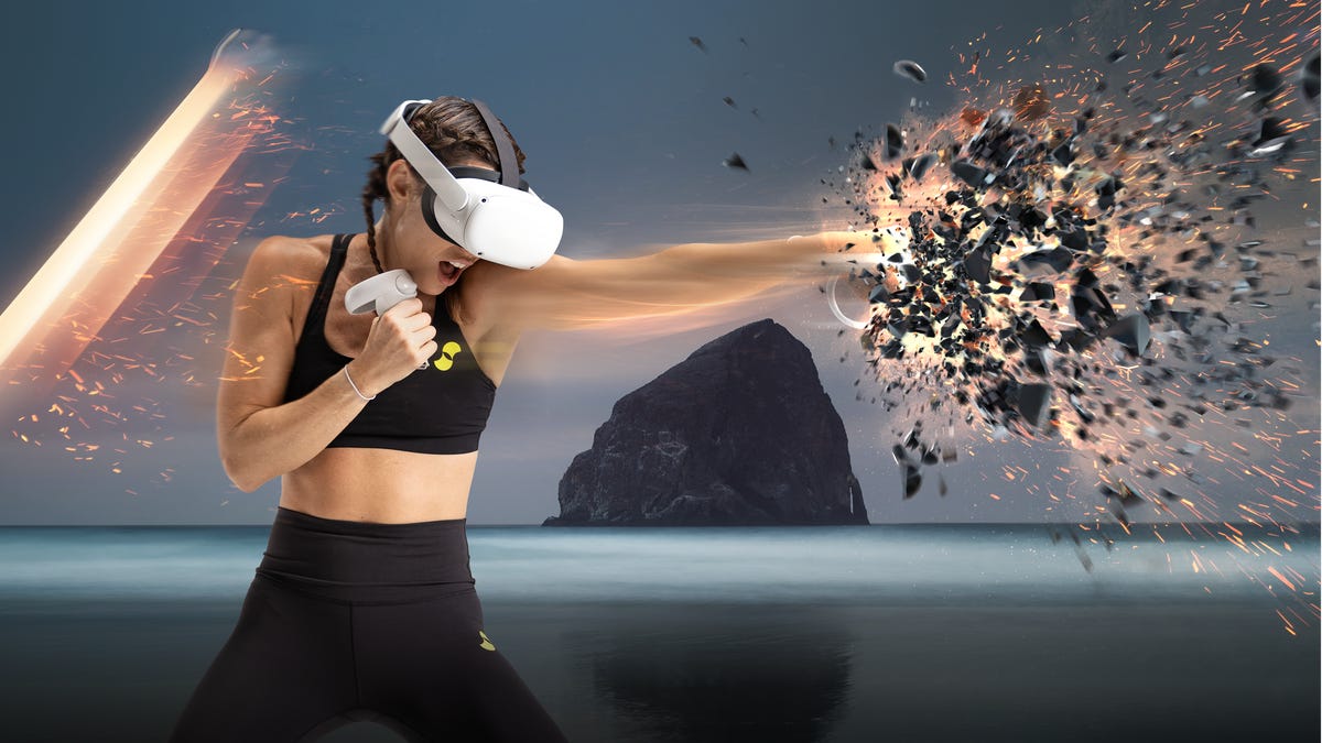 A woman wearing a VR headset punches an object, shattering it