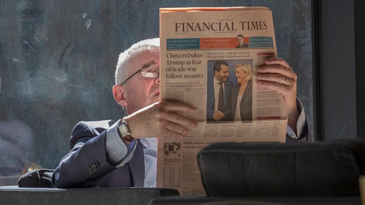 A man reading the print version of the Financial Times.
