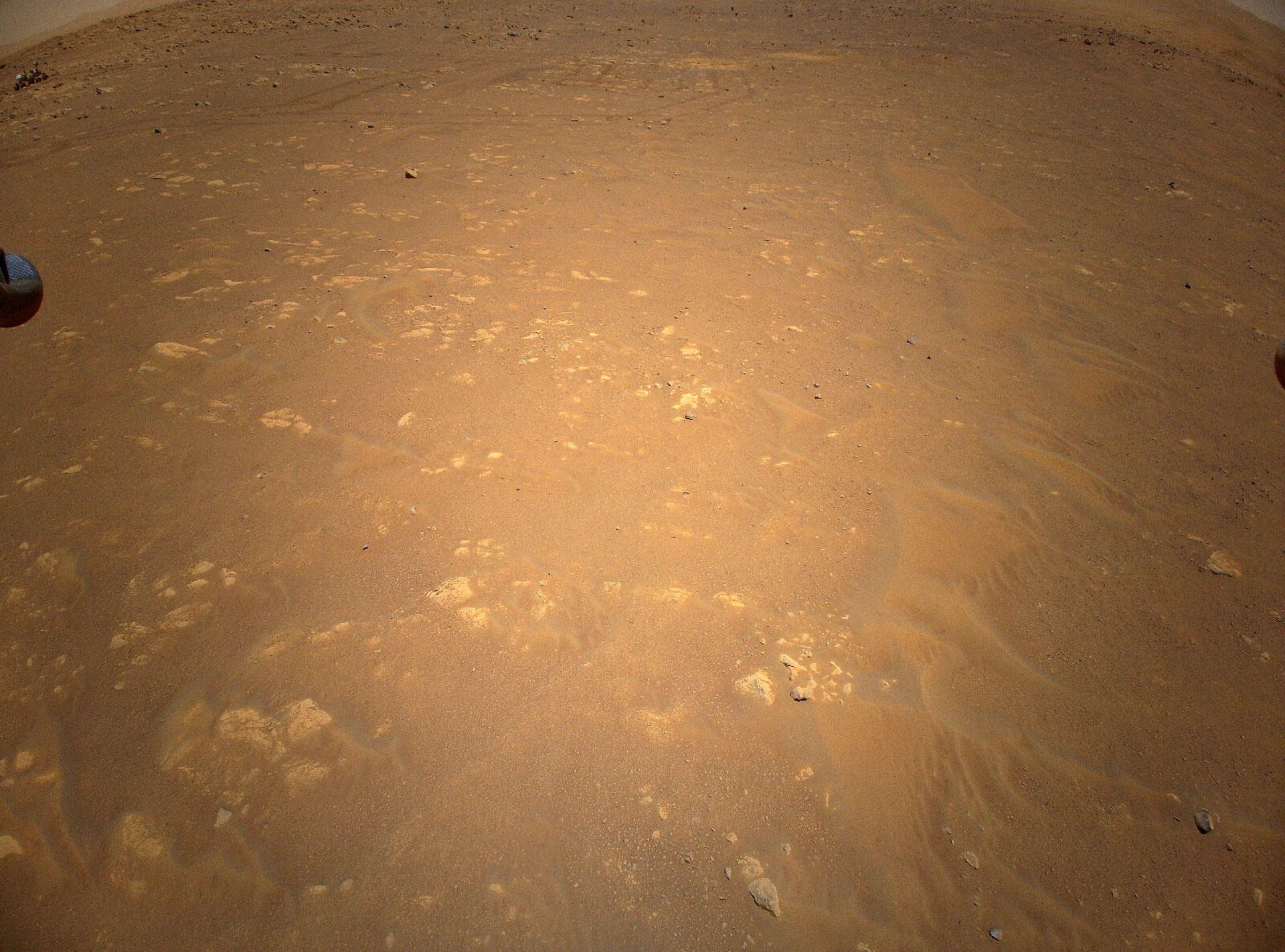 Photo of Mars from the Ingenuity helicopter, with the Perseverance rover in one corner