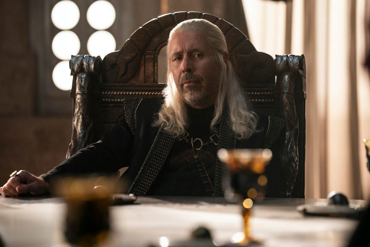 Paddy Considine as King Viserys Targaryen, sitting at the Small Council's meeting table