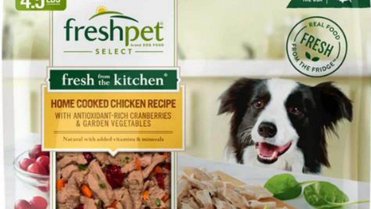 The front of a Freshpet bag of dog food featuring a happy dog, carrots and chopped chicken pieces