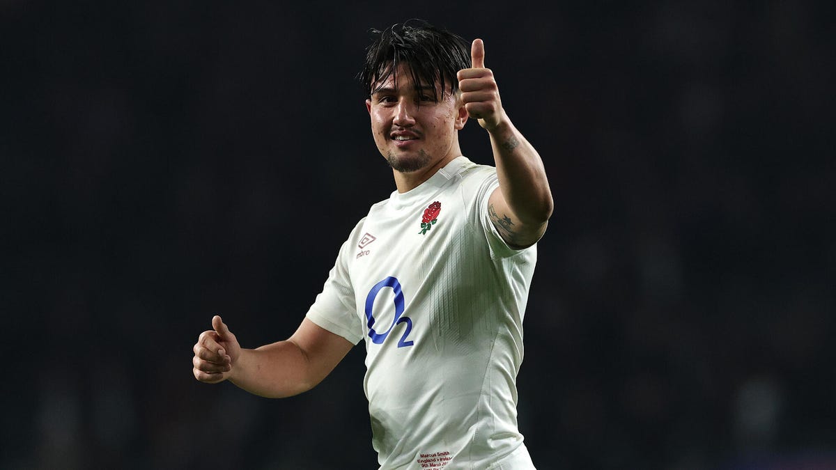 England rugby player Marcus Smith smiling celebrating, making a thumbs-up gesture with his left-hand.
