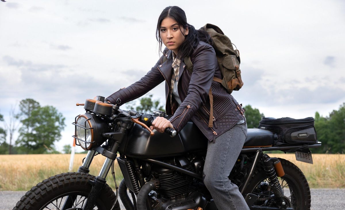 mujer con mochila se sienta en motocicleta