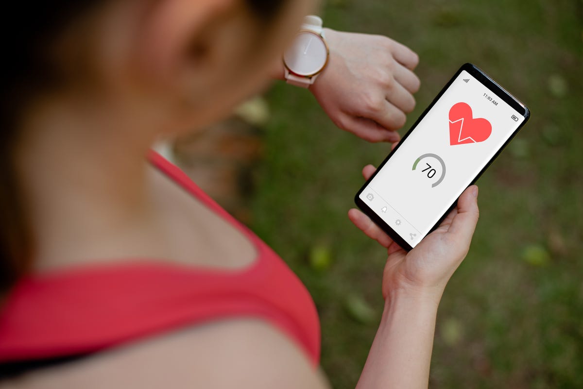 Person checks their heart rate via their smartwatch and fitness app.