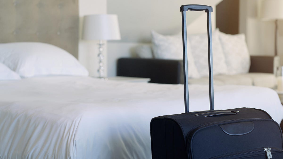 Travel hotel and luggage in a hotel room.