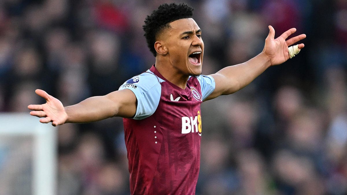 Aston Villa striker Ollie Watkins shouting with both arms outstretched.