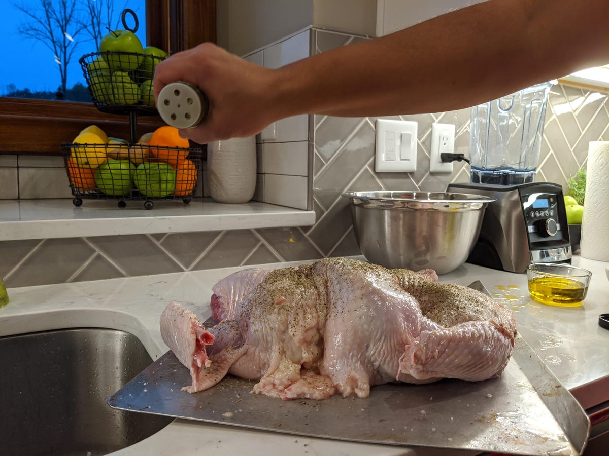 hand seasoning a whole turkey