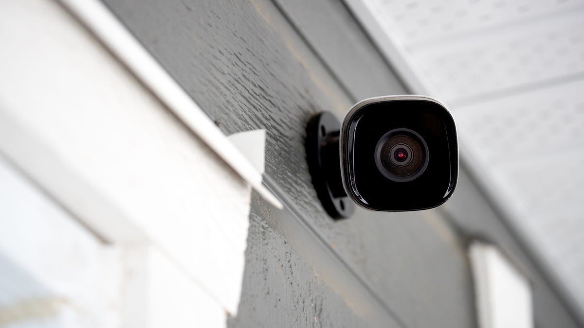 A security camera mounted above a window