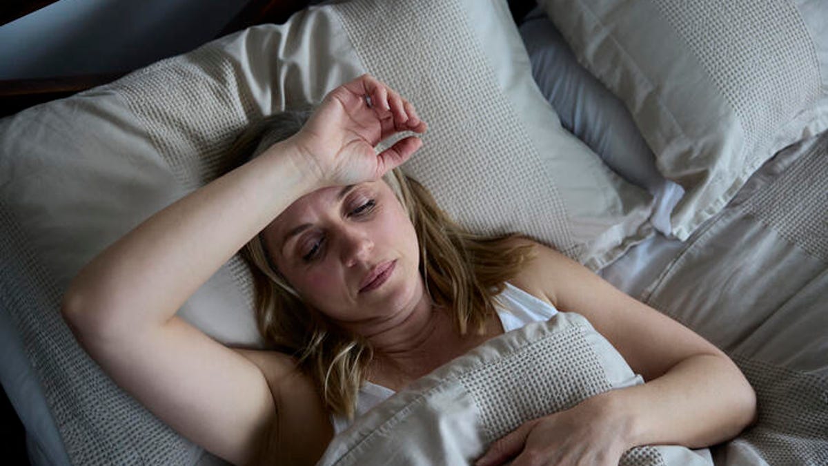 Woman awake in bed because she is too hot to sleep