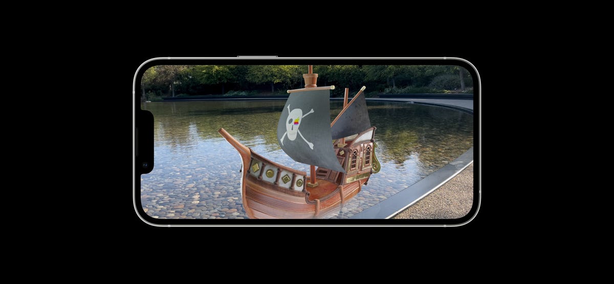 A virtual pirate ship sits on a real pond, seen on a phone screen.