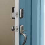 The Yale Assure Lock 2 shown on a blue door that's open to show both inside and outside components.