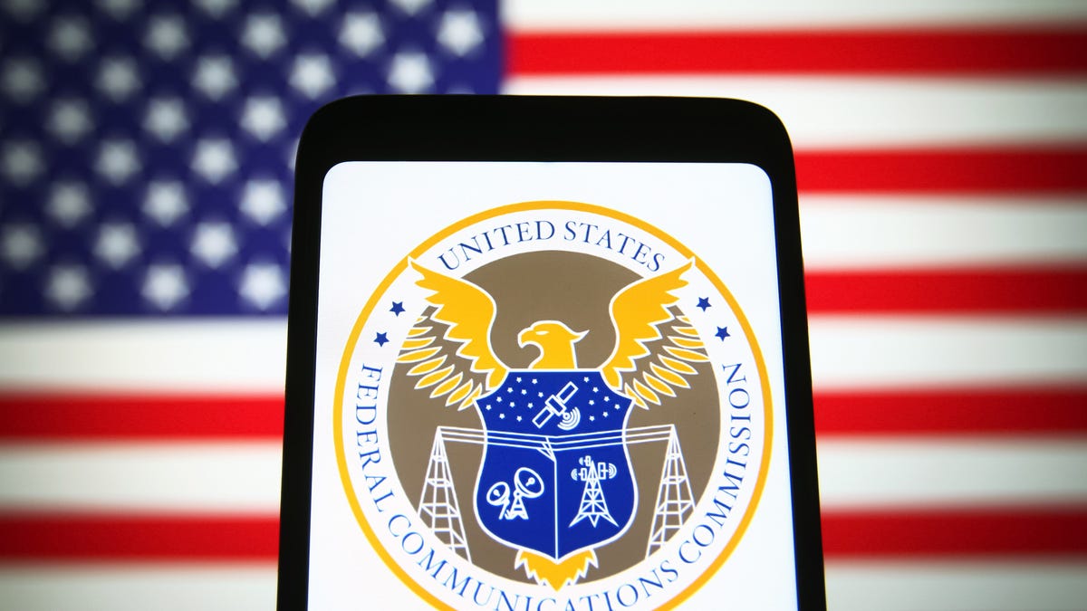 Phone showing the FCC logo, an American flag in the background
