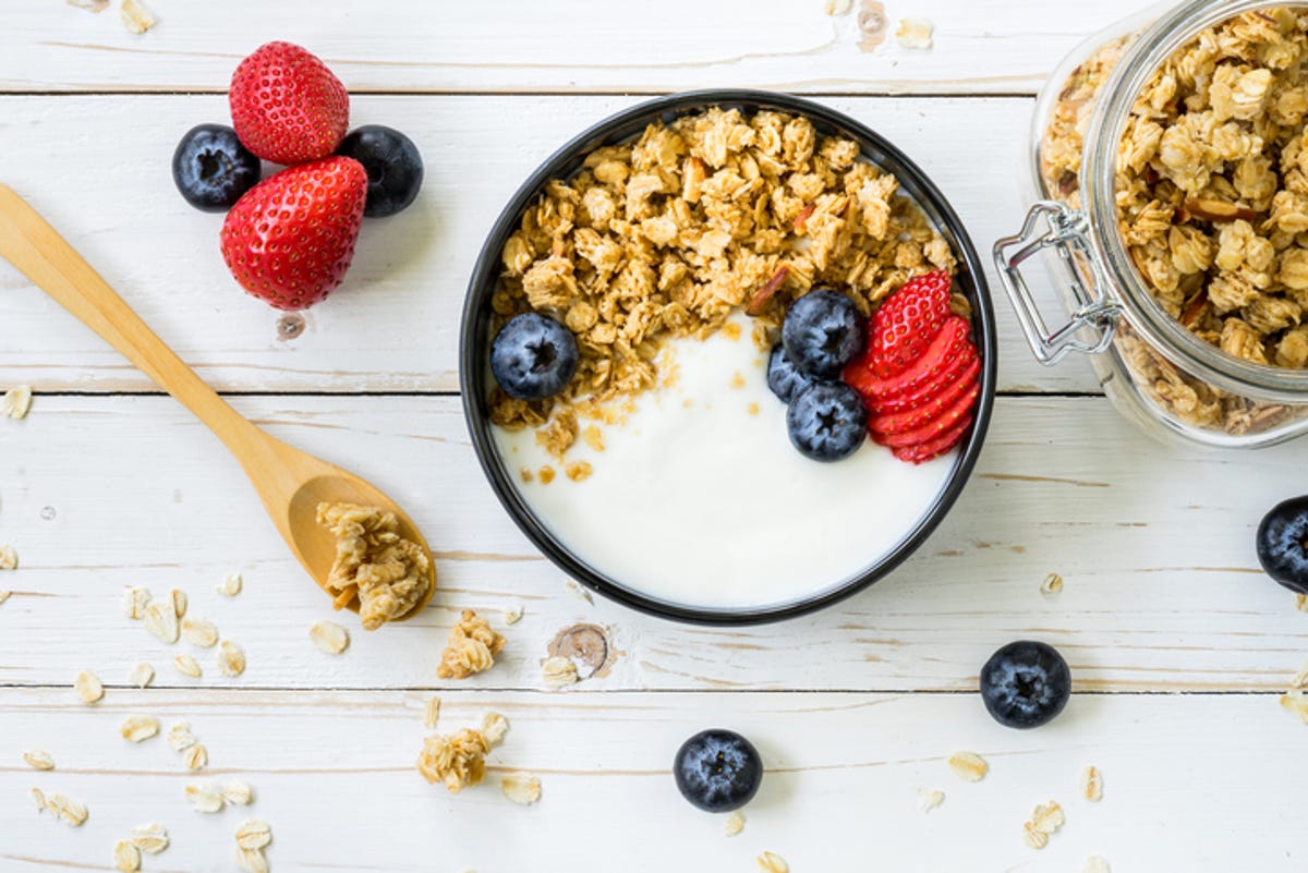 a bowl of yogurt with granola and berries