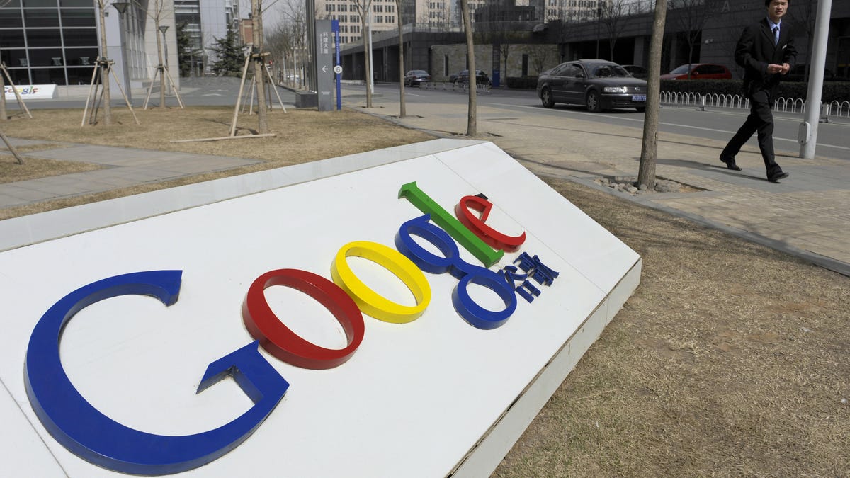 A man walks past the Google company logo