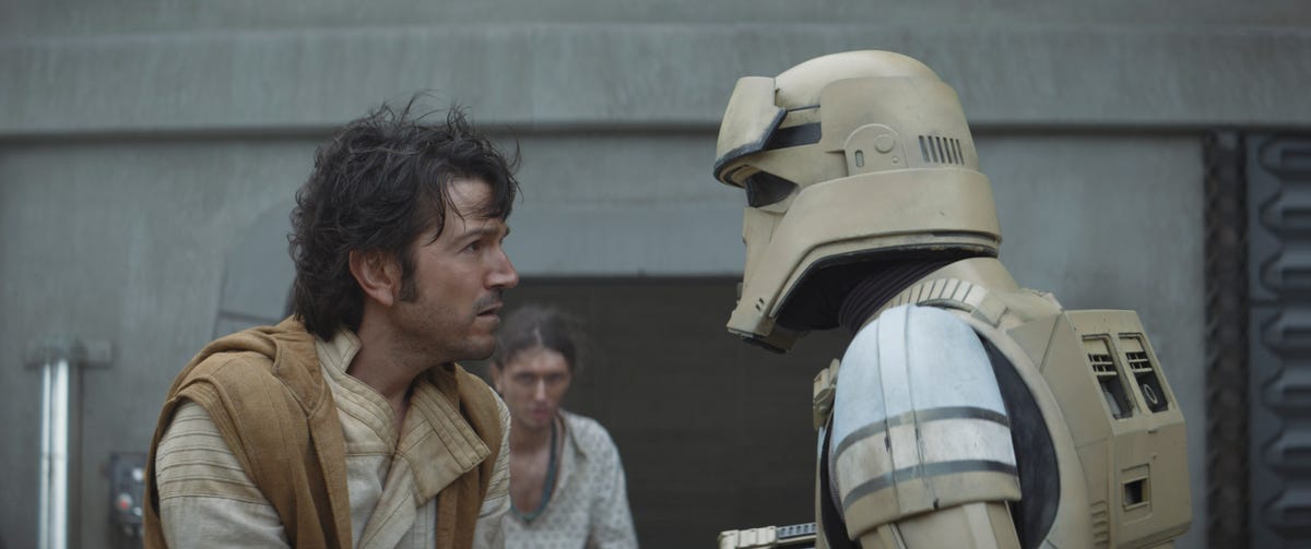 Cassian Andor, his hair blowing slightly in the wind, speaks to a shoretrooper in Andor