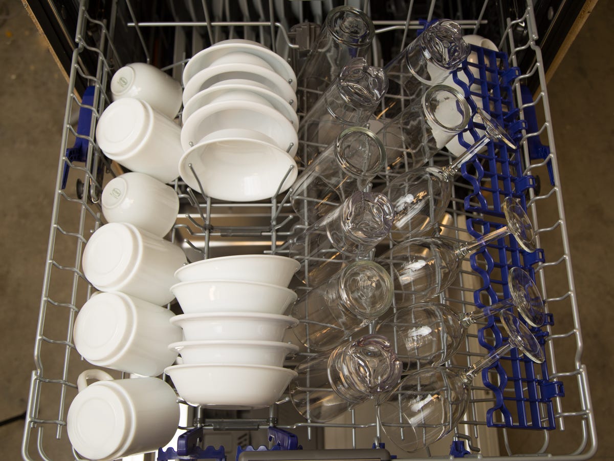Top-down view of clean dishes, bowls and mugs in a dishwasher.