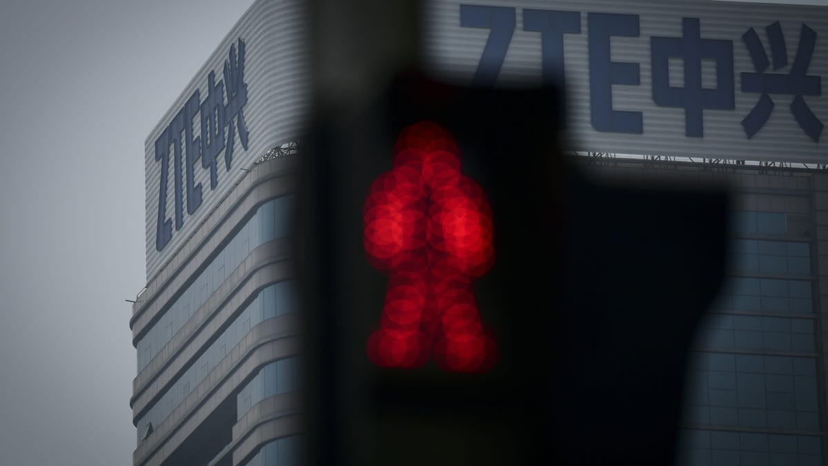 ZTE logo on a building, with a Don&apos;t Walk signal in the foreground.