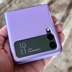 A hand holds a phone in a purple Spigen Thin Fit Galaxy Z Flip 3 case.
