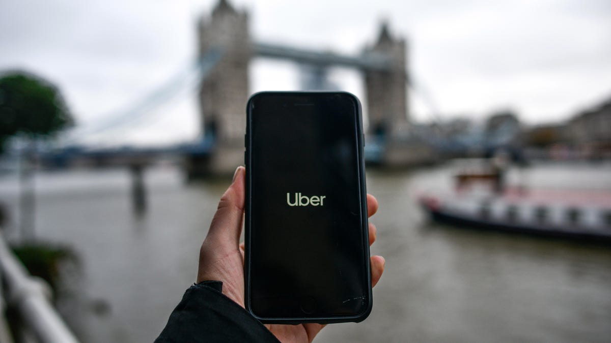 Uber logo on a smartphone screen in front of London&apos;s Tower Bridge