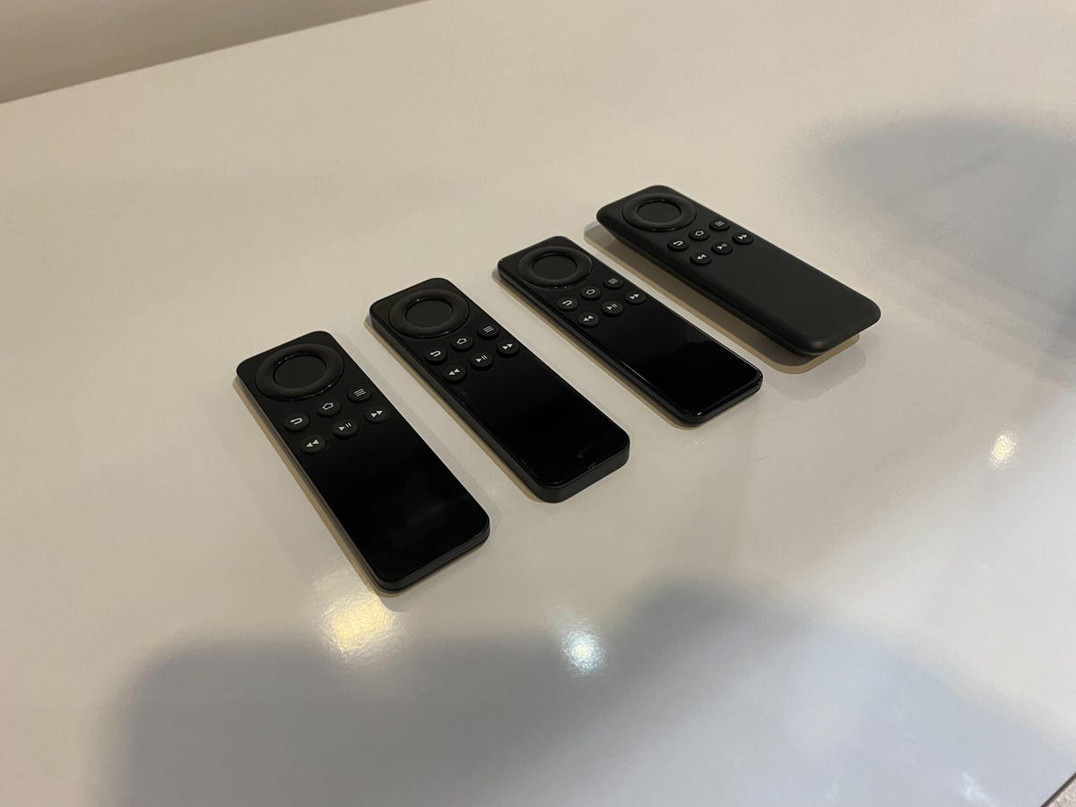 Four small remotes laying on a display counter.