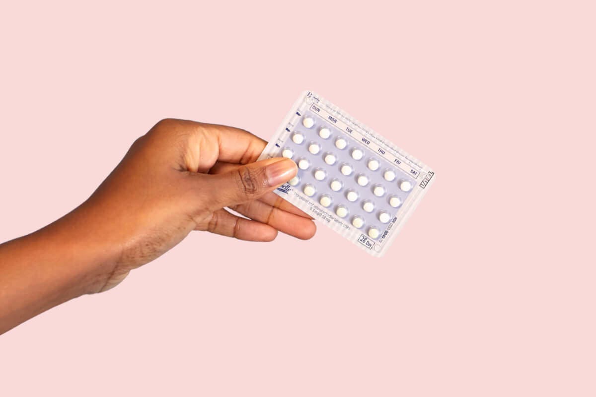 hand holding a sheet of birth control pills