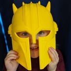 Small child wearing a helmet from the Mandalorian