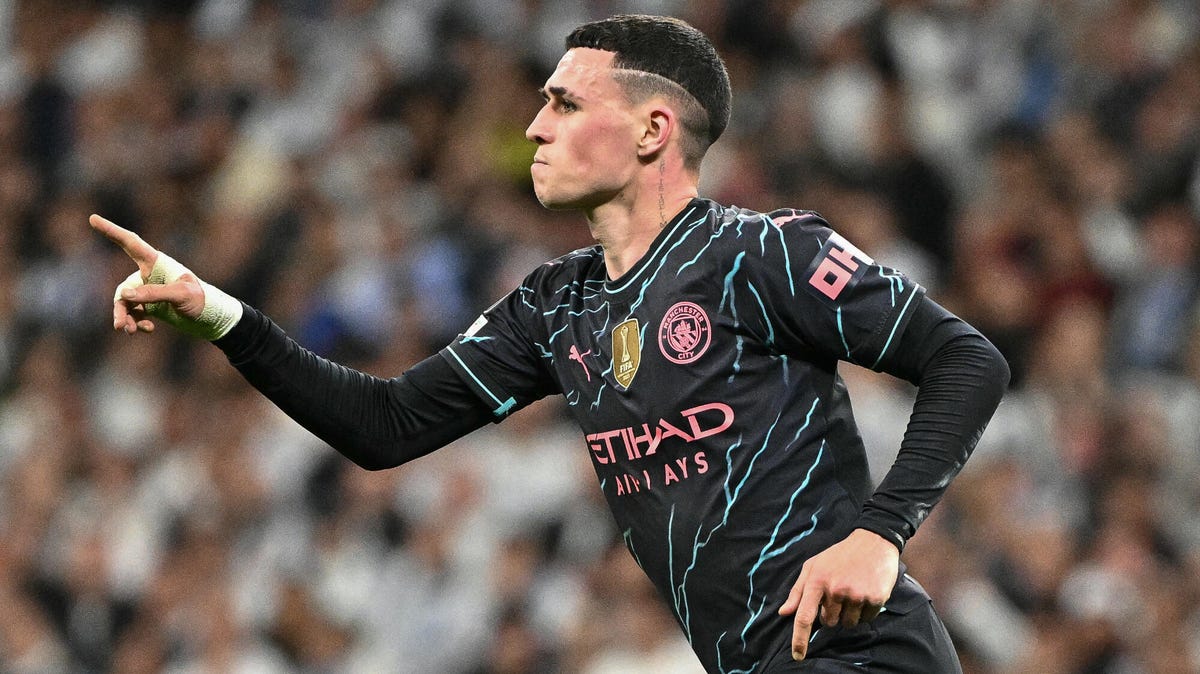 Side on image of Phil Foden, running, celebrating, posting with his right hand.