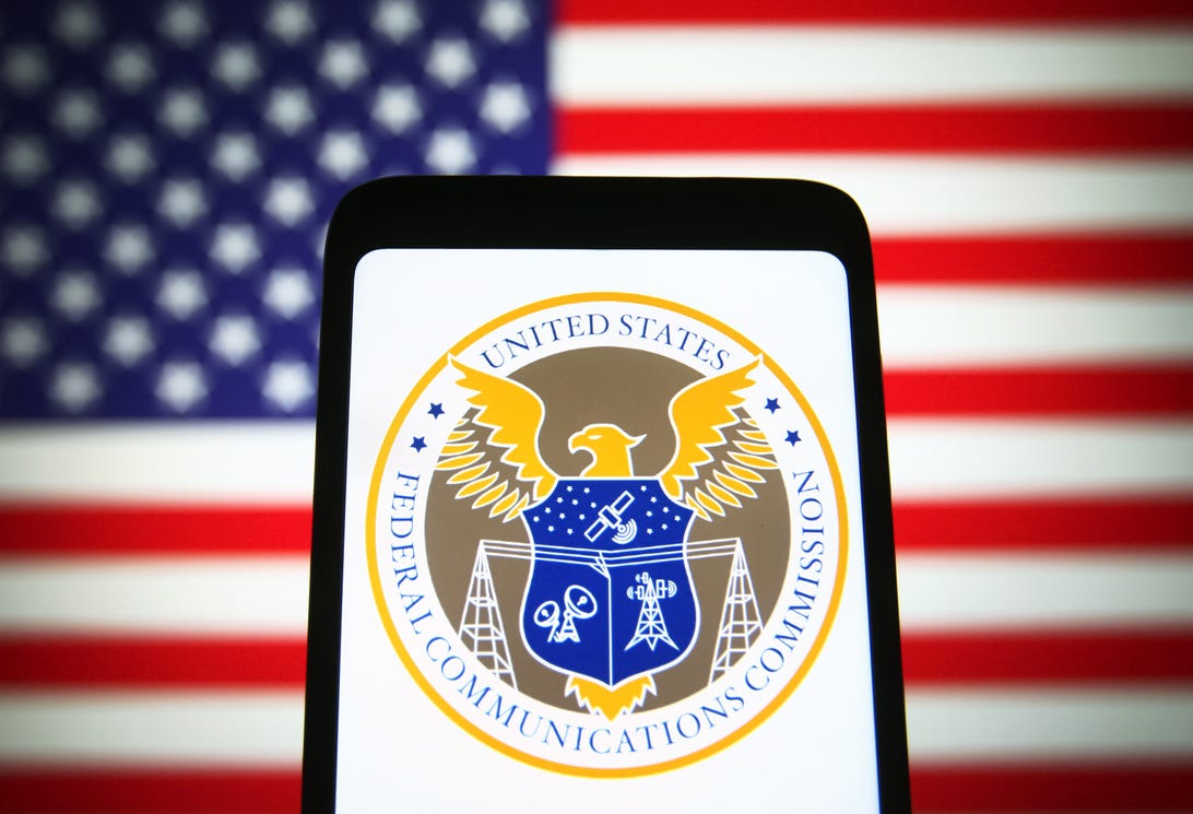 Image of telephone  with the FCC logo connected  the surface  and the American Flag successful  the background