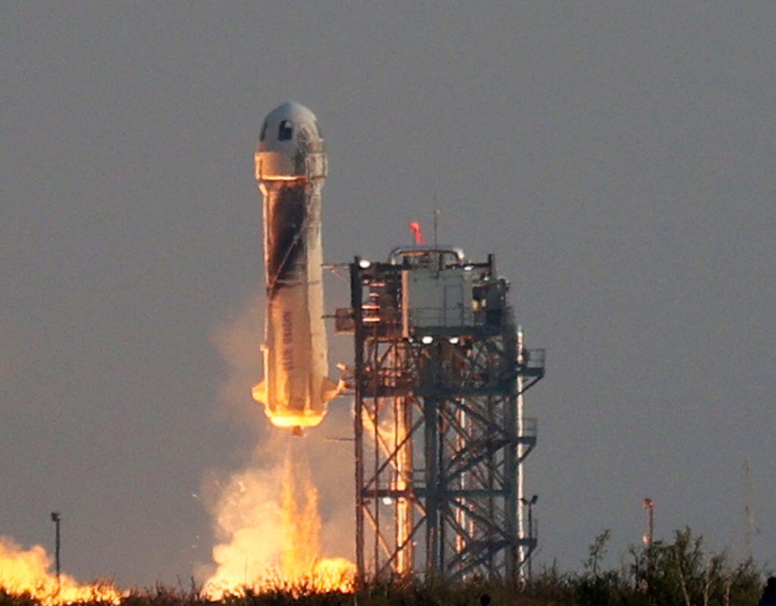 Blue Origin's New Shepard rocket thrusts its way skyward with Bezos aboard.