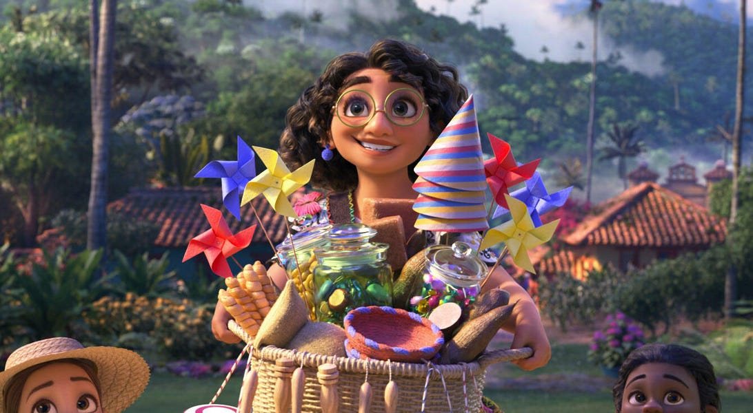 Encanto's protagonist Mirabelle smiles while holding a basket laden with colorful party favors. 